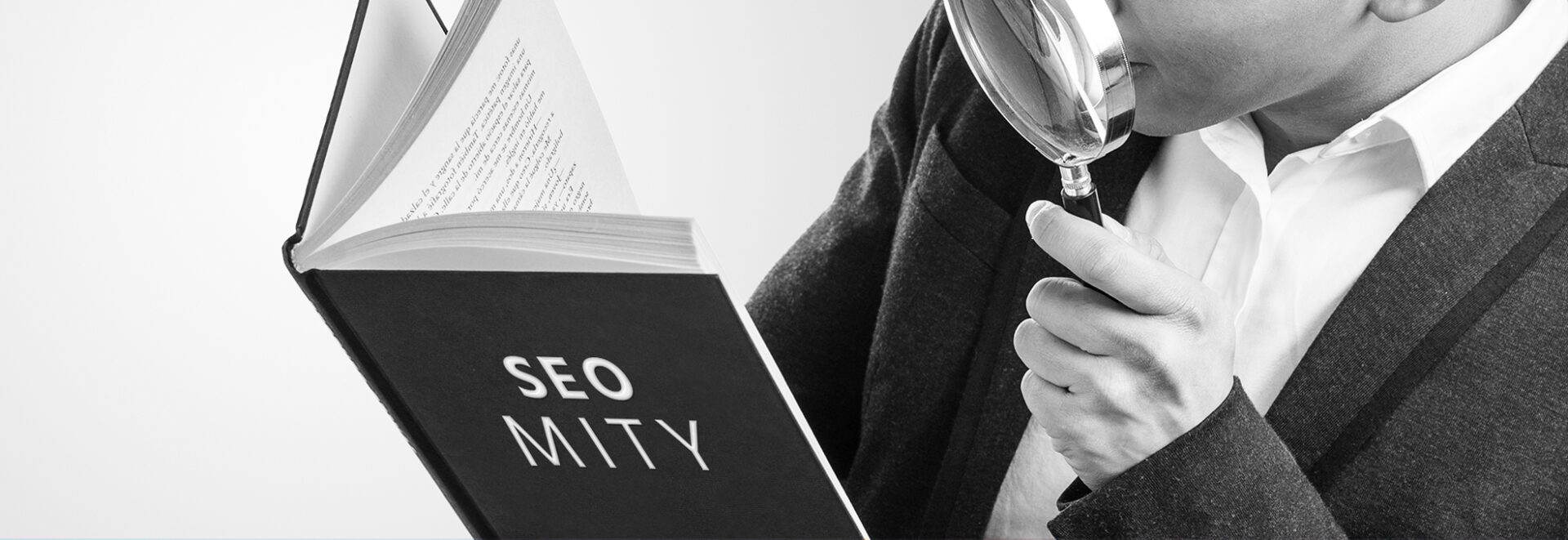 portrait of young asian business man looking through a magnifyin