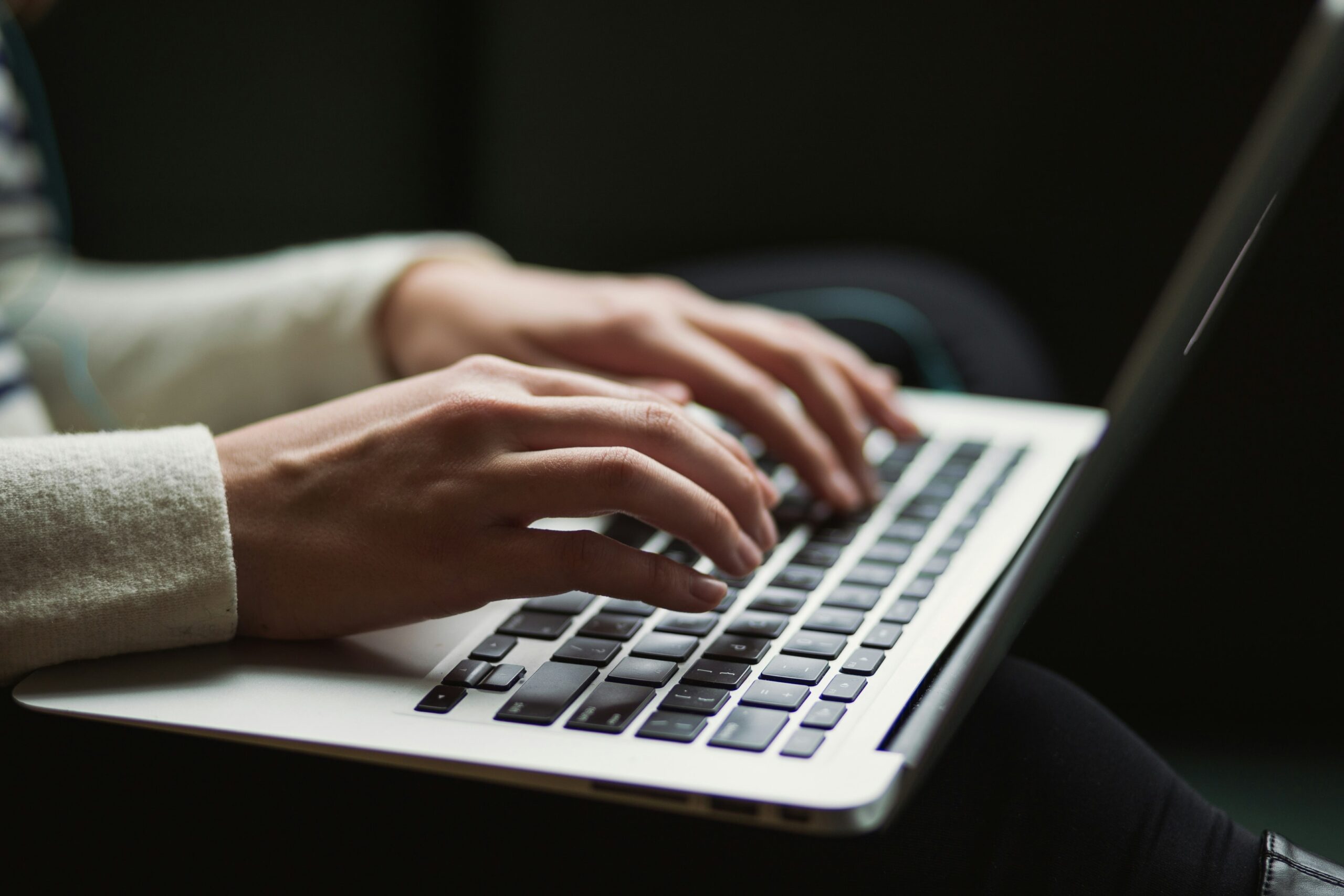 Zdjęcie dłoni piszących na laptopie